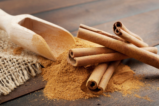 Cinnamon sticks and powder in wooden scoop
