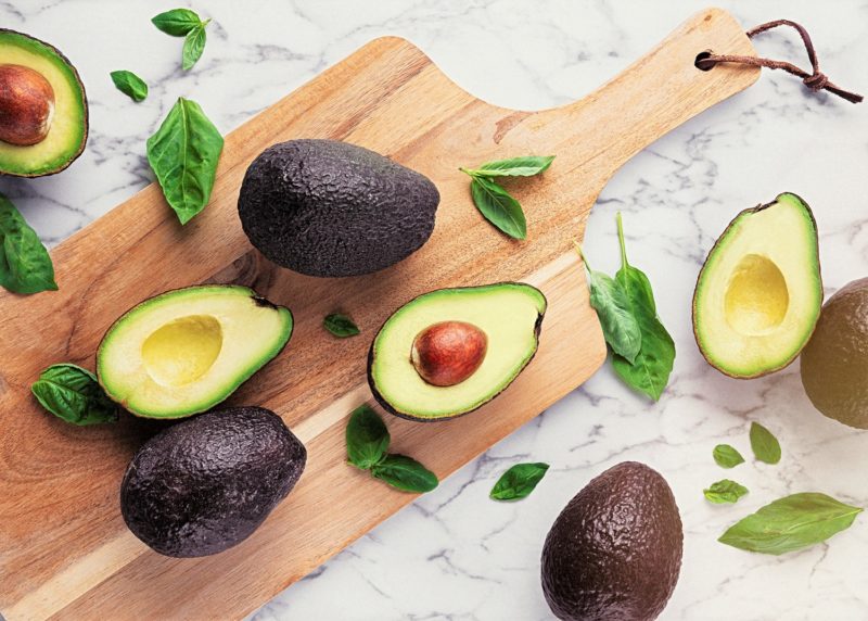 freshly cut avocados on a cutting board. metabolism boosting foods