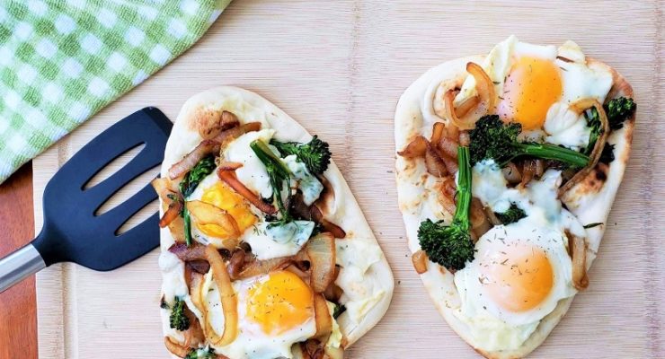 French Onion Breakfast Flatbread on naan with eggs, swiss cheese and broccolini