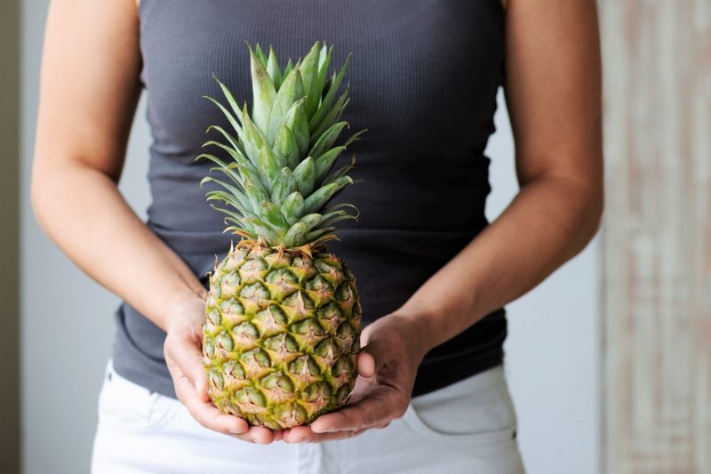 woman holding a pineapple