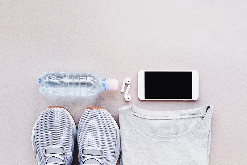 sneakers, water bottle, smart phone and wireless headphones