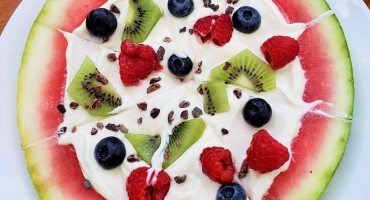 Watermelon Pizza topped with Greek yogurt, berries and cacao nibs