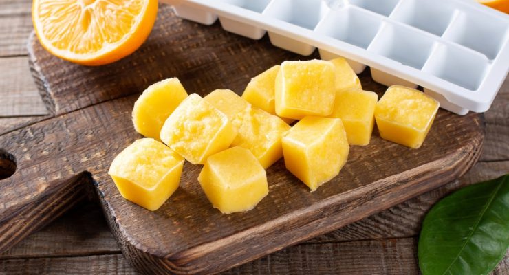 a plastic white ice cube tray next to pureed fruit ice cubes