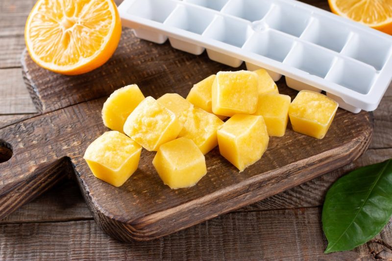 a plastic white ice cube tray next to pureed fruit ice cubes